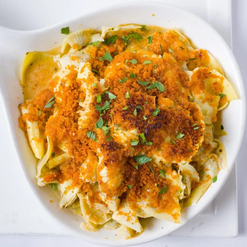 Davinci's baked pasta dish with golden breadcrumbs and fresh parsley in a white bowl.