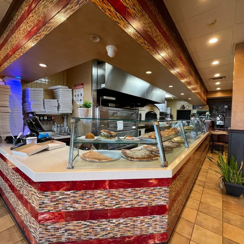 Interior of Davinci's Italian restaurant, showing a counter with pizza, sandwiches, and a pizza oven.